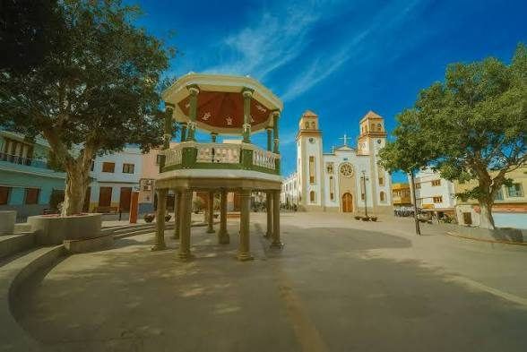 Plaza y kiosco de La Aldea de San Nicolás al atardecer, con la iglesia al fondo